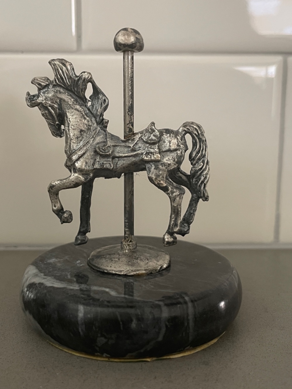 A vintage pewter carousel horse figurine on a marble base.